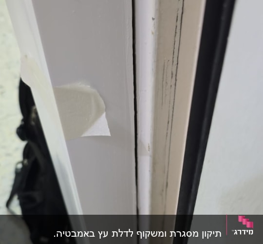 דלת עם מסגרת לבנה וסימני שחיקה